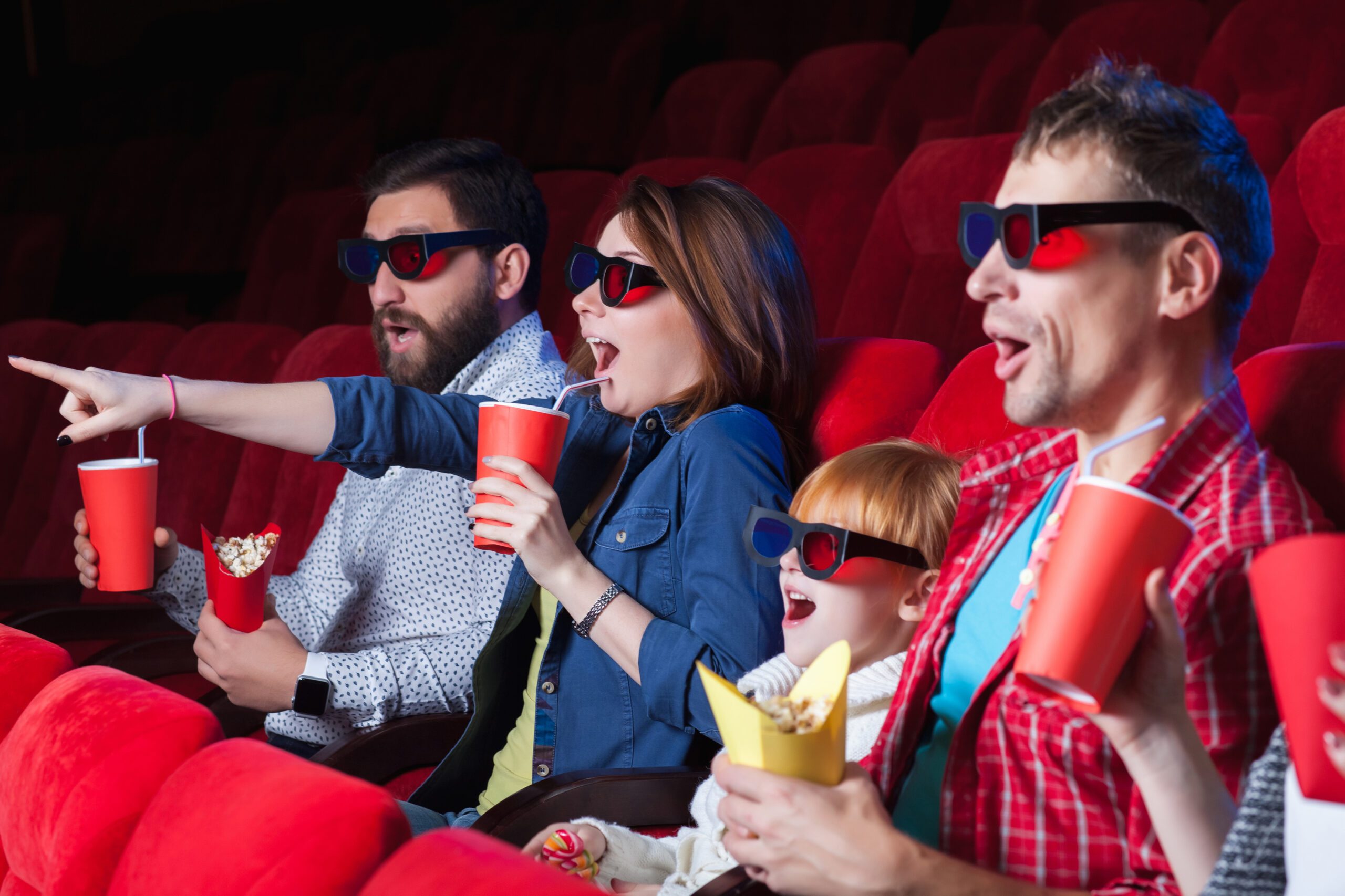 A variety of human emotions of friends holding a cola and popcorn in the cinema.
